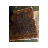 Early 20th century Middle Eastern floor rug decorated with stylised detail on a blue background,