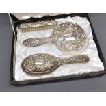 Silver-backed three piece dressing table brush and mirror set, in fitted case