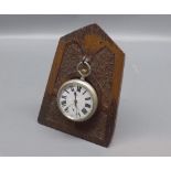 Omega base metal cased pocket watch and accompanying easel backed oak stand (2)