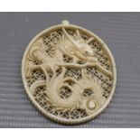 Early 20th century Chinese pierced ivory pendant, decorated with a dragon, 2" long