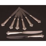 Eight 20th century dinner knives, each with plain and polished stainless steel blades and applied