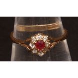 20th century ruby and diamond ring, the small centre circular cut ruby surrounded by eight small