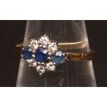 Modern sapphire and diamond lozenge-shaped ring, a line of three circular cut sapphires surrounded