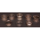 Mixed Lot: three silver circular napkin rings with engine-turned decoration, together with five