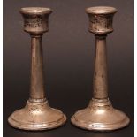 Matched pair of George V candlesticks, each with waisted sconces on tapering columns and spreading