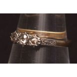 Precious metal three small stone diamond ring, set with three old cut stones having engraved