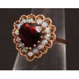 Modern 9ct gold dress ring, the central heart-shaped facetted red stone surrounded by fifteen