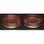 Two Elizabeth II bottle coasters, each of plain polished circular form with rolled rims and