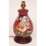 Modern Moorcroft table lamp, decorated with a tube-lined stylised floral pattern on a red ground, 8"