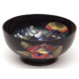 Moorcroft circular bowl of tapering form, decorated with an orchid design on a dark blue ground,