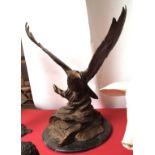 Bronze patinated metal study of an eagle with outstretched wings resting on a marble or