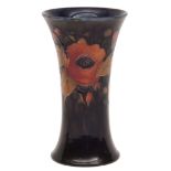 Moorcroft trumpet vase, decorated with a pomegranate design on a dark blue ground, impressed marks