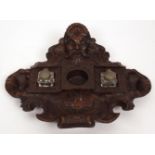 Unusual carved oak inkstand of oval form moulded with mask and scrolls and with central fittings