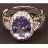 Modern tanzanite and diamond ring, the oval cut tanzanite (3.88ct app), claw set in a surround of