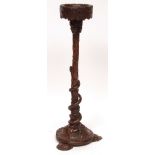 An unusual carved oak jardini re stand, elaborately carved with foliage and the stem decorated