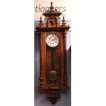 Late 19th century walnut and ebonised twin weight-driven Vienna type wall clock, the overhanging