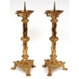 Pair of heavy brass ornate altar candlesticks, pierced balustered stems terminating in triangular