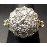 Precious metal diamond cluster ring, a large disc (15mm diam) set with 21 small brilliant cut