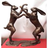 Pair of bronze patinated metal sculptures depicting fighting hares, modern, approx 35" high