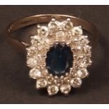 White gold sapphire and diamond cluster ring, the oval sapphire (approx 8 x 6mm), surrounded by