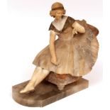 Art Deco period alabaster figure formed as a seated lady wearing a ball gown with integral socle,