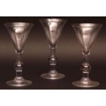 Set of three Georgian style ale glasses, with funnel bowls over balustered air drop stems