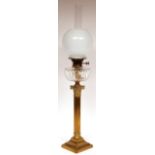 Victorian oil lamp with milk glass shade over a clear glass faceted font and raised on a brass