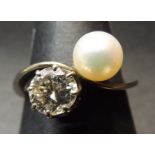 Precious metal diamond and pearl cross-over ring, the circular brilliant cut diamond in a coronet