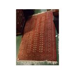 20th century red wool machine made floor rug decorated with panel of lozenges, 6ft long