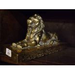 Brass door stop formed as a recumbent lion on plinth base, 11 1/2" long