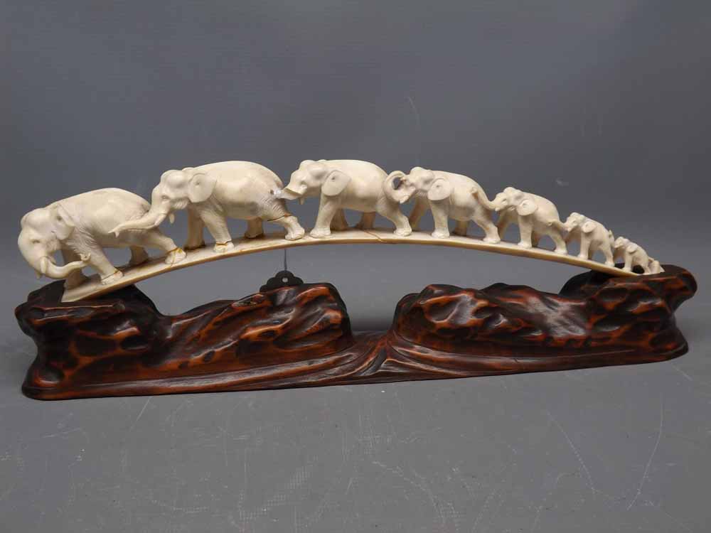 Early 20th century carved ivory parade of elephants and accompanying hardwood base, (Note: the ivory