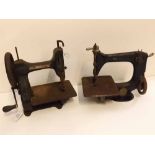 Two small vintage sewing machines, one marked "The Singer Manufacturing Co" and the other marked "