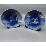 Pair of Royal Doulton blue plates with decorative scenes of a child on a log with a frog, and
