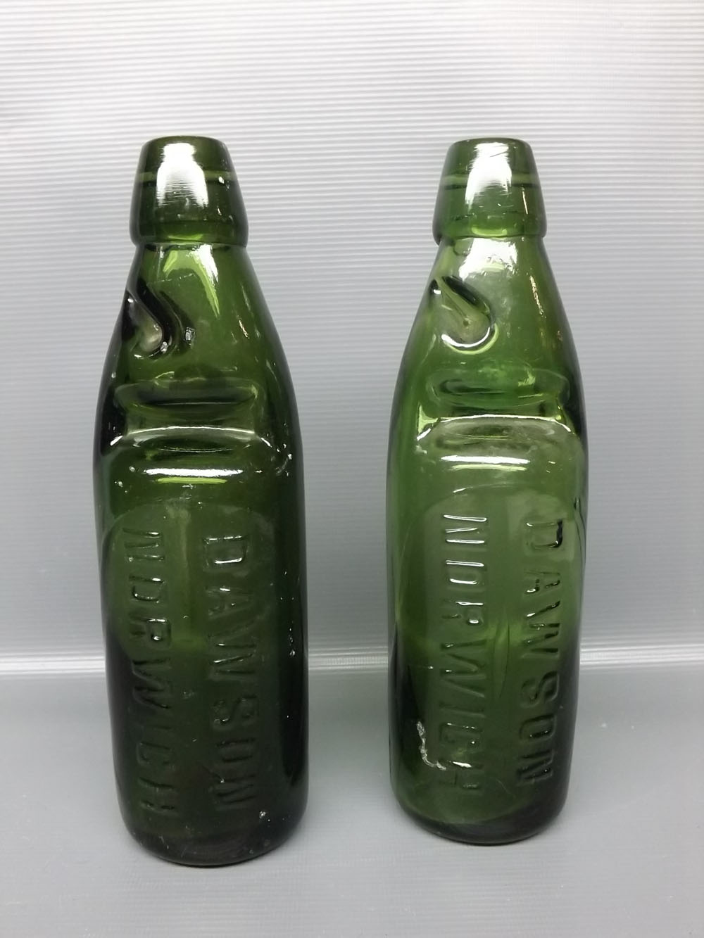 Two dark green glass Codd bottles, Dawson's Norwich, height 9" (2)