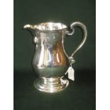 Mid C18th style silver wine jug the baluster body with Rococo chased neck and capped bracket handle,