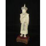 Japanese carved ivory Okimono as a bearded elder wearing elaborate costume on hardwood base,