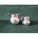 Edwardian silver milk jug with ribbed neck and handle, London 1905, a similar smaller jug, 1905 14.