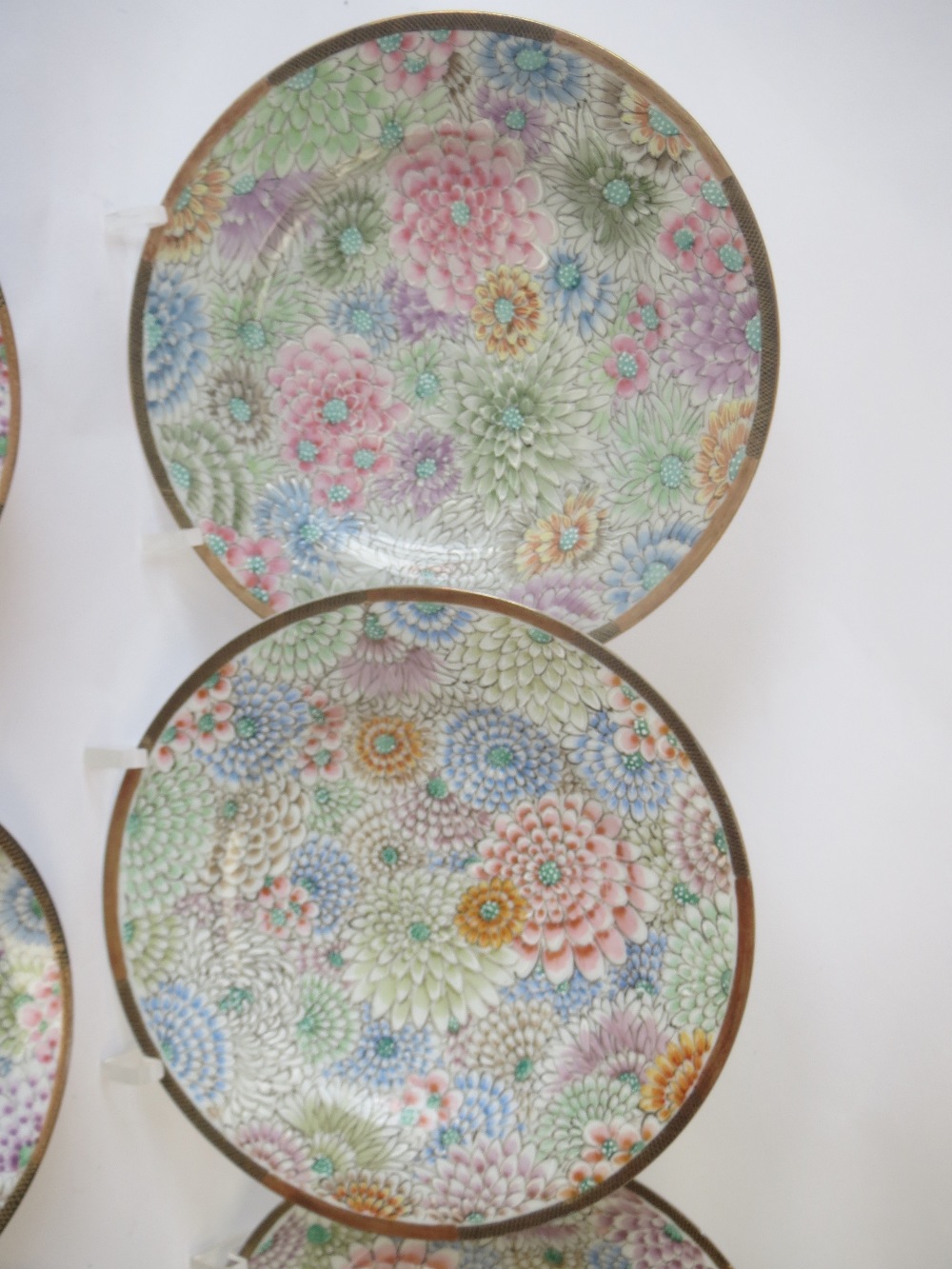 Set of four Japanese tea plates decorated multicoloured chrysanthemums to a black and gilt border - Image 3 of 4