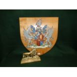 Brass door stop in form of male lion 18cm H x 23cm W, heraldic shield with winged griffith and