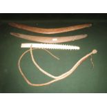 Two vintage boomerangs of typical curved outline largest 76cm long, two African bull pizzle whips