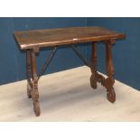 C17th Spanish walnut side table, with a plain single plank top on shaped trestle end supports,