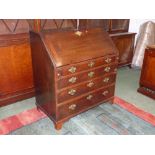 George III mahogany bureau of four long graduated drawers with brass handles below a fall flap