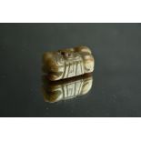 Chinese greenish brown and russet jade carving of a recumbent tiger, Ming/Qing Dynasty, 5cm long.