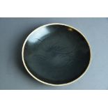 Rare Chinese ‘Ding’ type black-glazed dish, carved to the interior with lotus flowers, Song