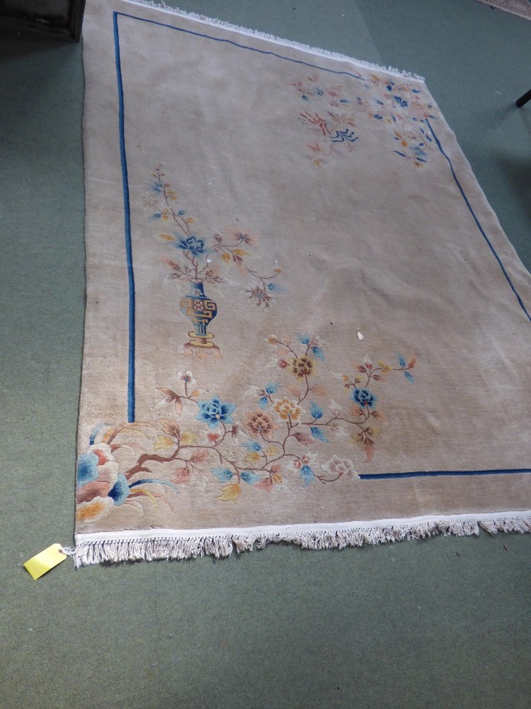 Washed Chinese carpet fawn ground decorated with branches within blue band 355 cm x 260 cm