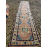 Persian style runner with borders of cream, blue and pinks and central motifs 370 cm x 94 cm