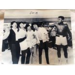 Muhammad Ali. Large mono copy photograph of Ali in a boxing ring with 'The Beatles'. Signed by