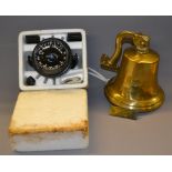 A modern brass shipping bell along with a gimballed compass