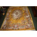 A thick-pile floor rug with floral decoration against a yellow and cream ground.