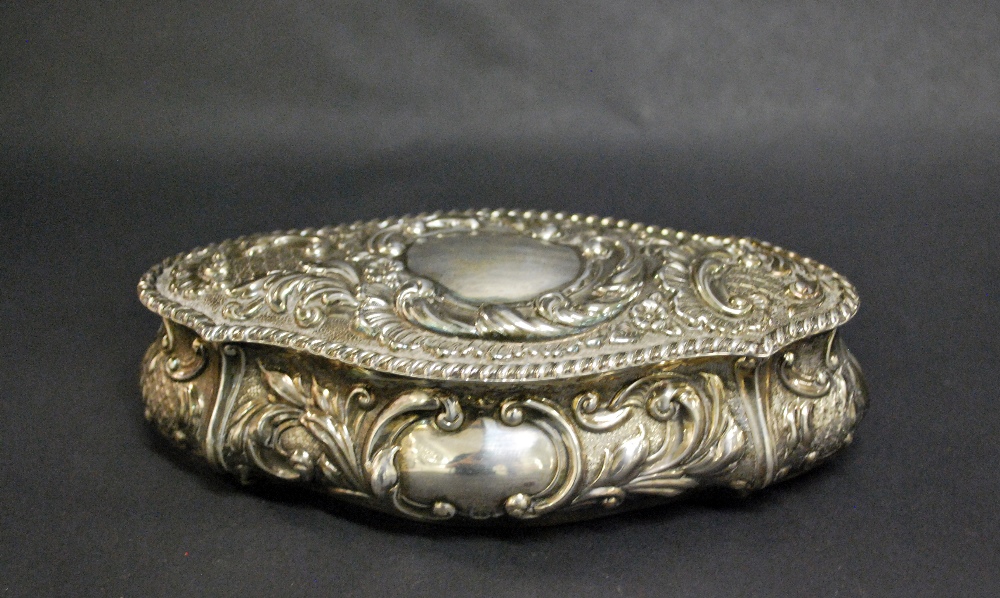 A hallmarked silver repoussé decorated trinket box, with a gilt washed interior and hinged cover.